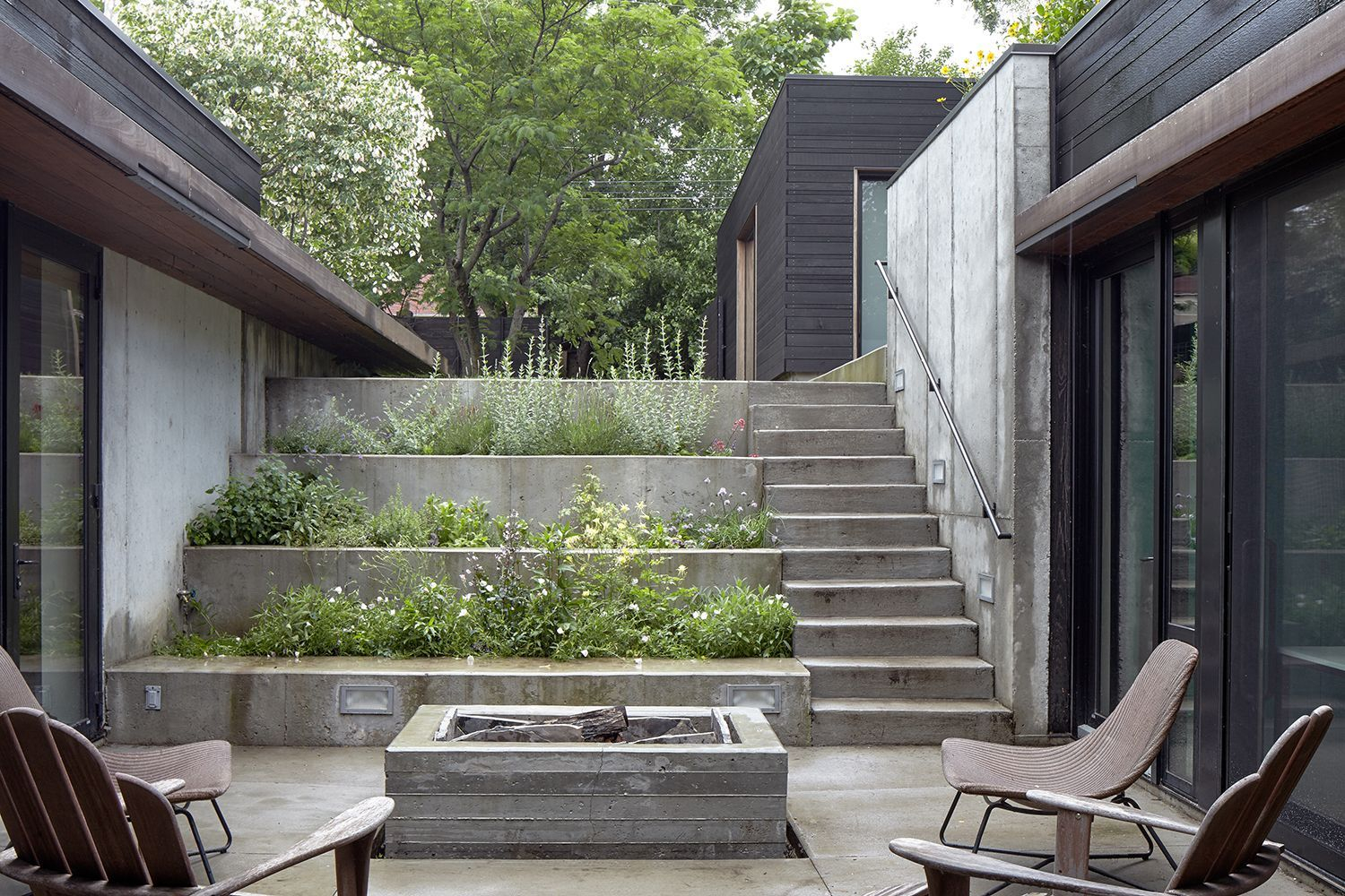 A Stepped Concrete Garden Planted With Herbs And Flowers Marks The ... intended for Transforming Gardens with Thoughtfully Designed Concrete Walls